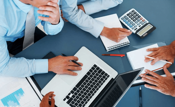 Un gruppo di uomini d'affari che collaborano su un laptop.