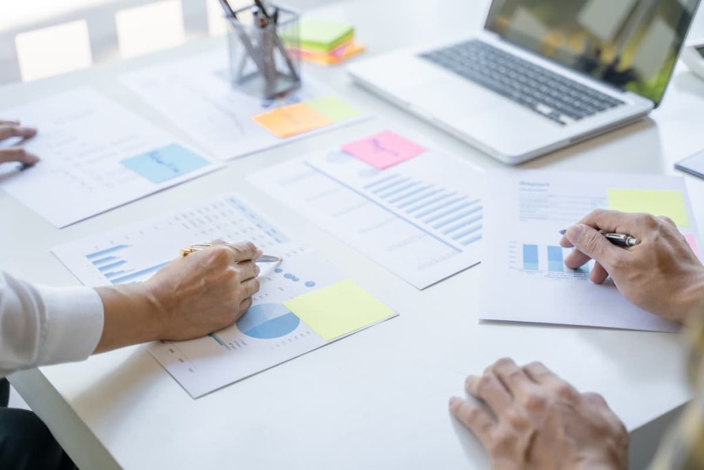 Un gruppo di persone che collaborano a un tavolo aperto con documenti, mostrando perché scelgono Per chi è.