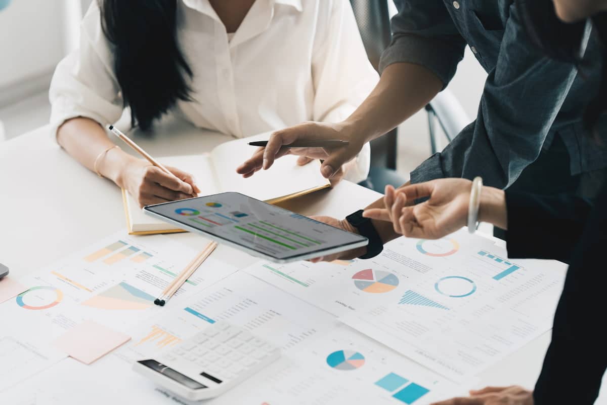 Un gruppo di uomini d'affari analizza i grafici su un tablet utilizzando Scopri.