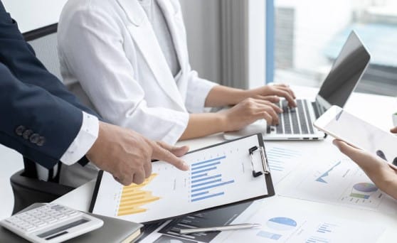 Un gruppo di dirigenti aziendali del Trovabando seduti attorno ad un vecchio tavolo.