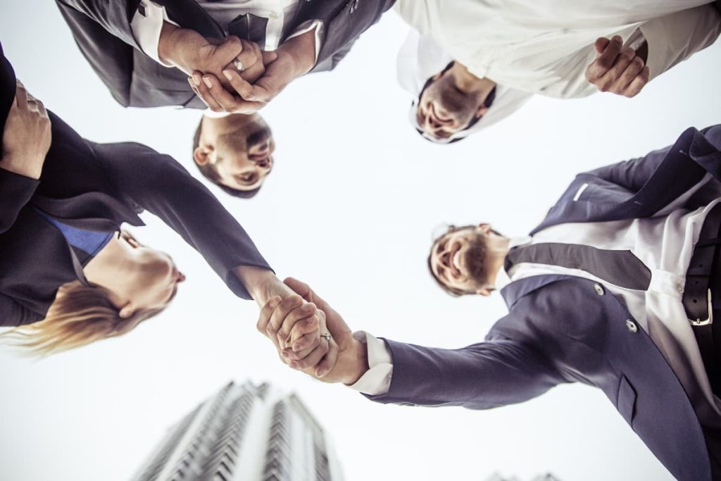 Uomini d'affari che si stringono la mano in un circolo aziendale.