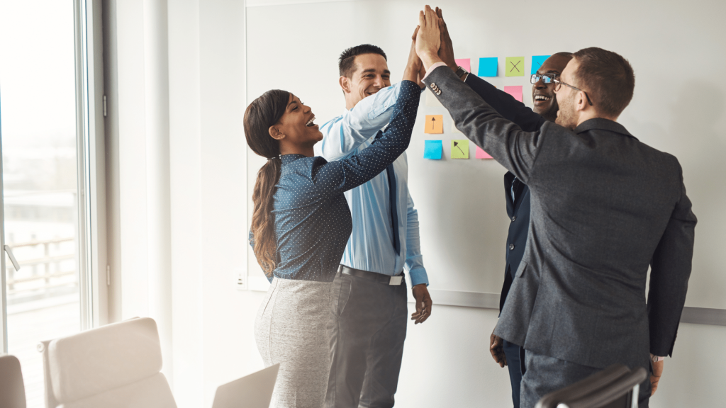 Un gruppo di uomini d'affari celebra la propria visione di successo in un ufficio.